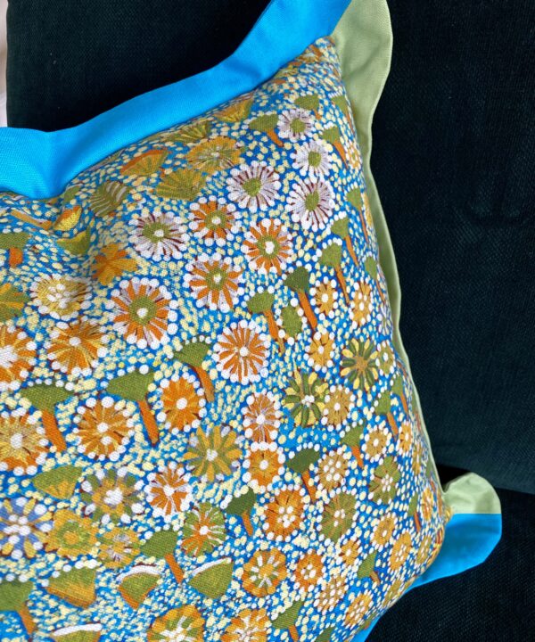 Brightly-coloured handmade linen and cotton cushion handmade using Aboriginal art print fabric.