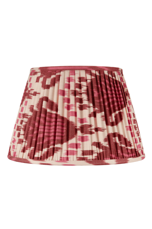 A burgundy silk lampshade with an Ikat design across the pleats.