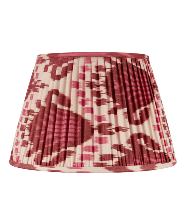 A burgundy silk lampshade with an Ikat design across the pleats.