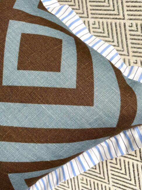 Diamond geometric printed linen in blue and brown on a cushion reverse with striped cotton trim.