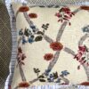 A vintage floral cushion with a blue stripe trim.