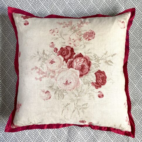 A vintage flowers cushion with a scarlet silk trim.