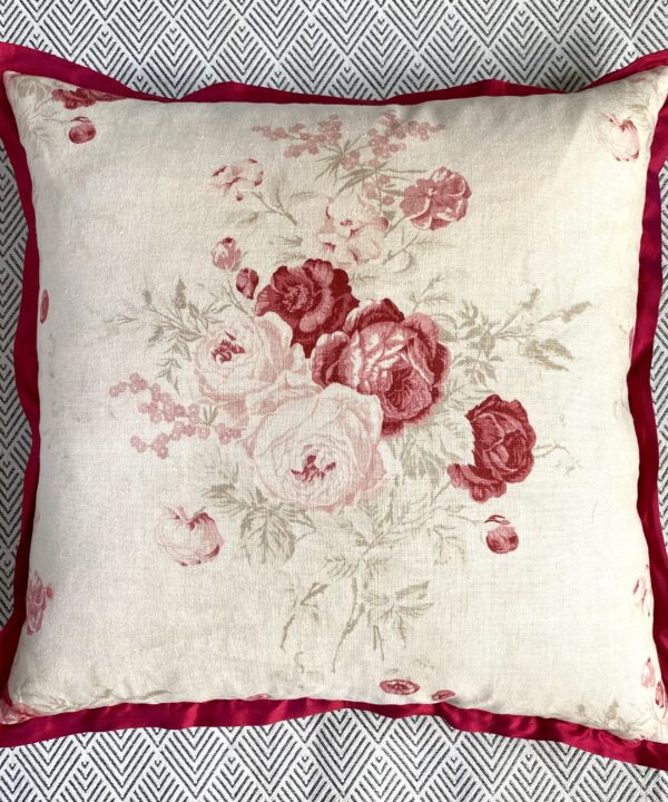 A vintage flowers cushion with a scarlet silk trim.