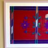 Handmade embroidery art textile from Mexico framed in a lilac frame.