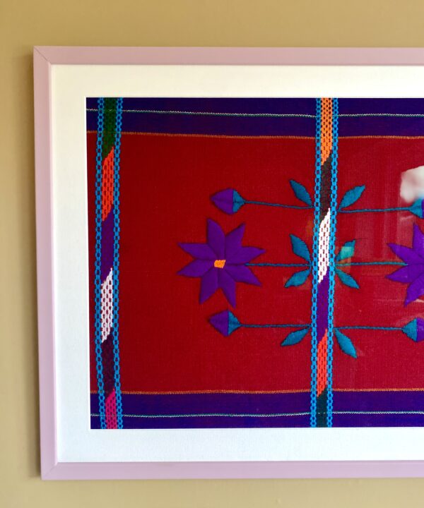 Handmade embroidery art textile from Mexico framed in a lilac frame.