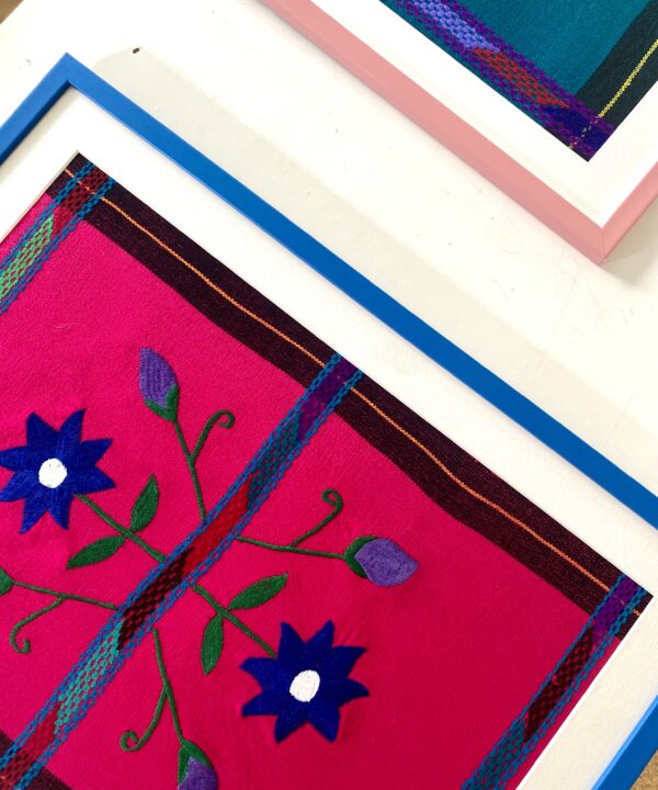 Close-up of a Royal framed Mexican textile in blue and hot pink.