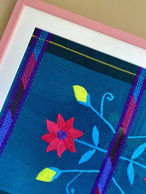 Pink framed embroidery art hand-stitched in Chiapas, Mexico.