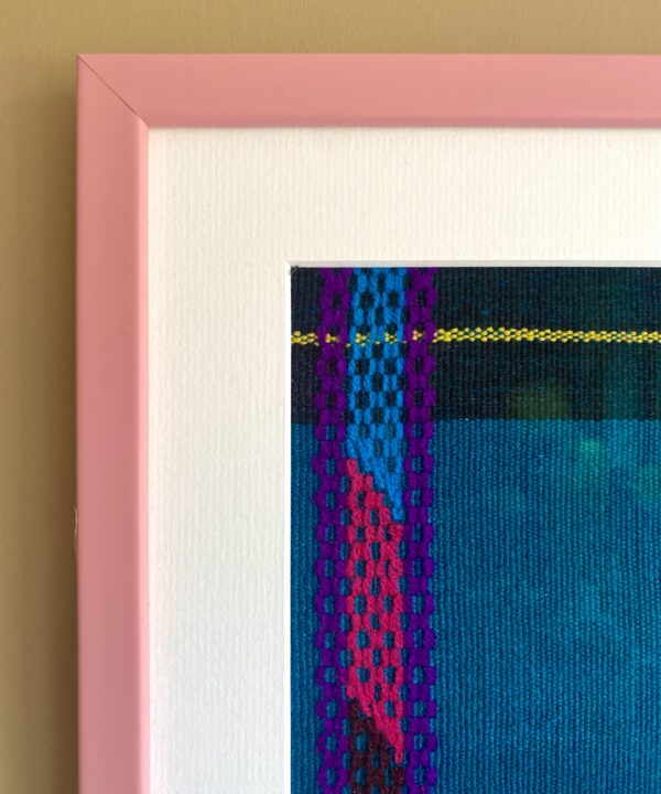 Corner detail of a smart, baby pink frame used for textile wall art.