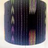 Black lampshade with eclectic, South East Asian pattern detailing.