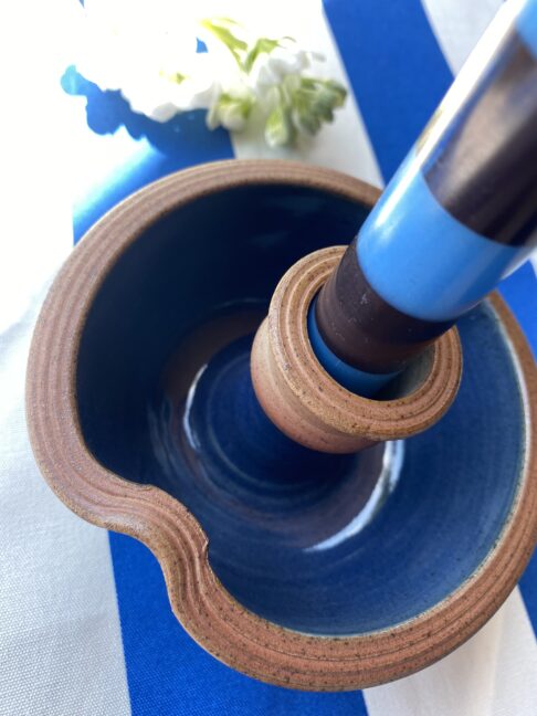 Close up shot of a blue pottery candlestick.