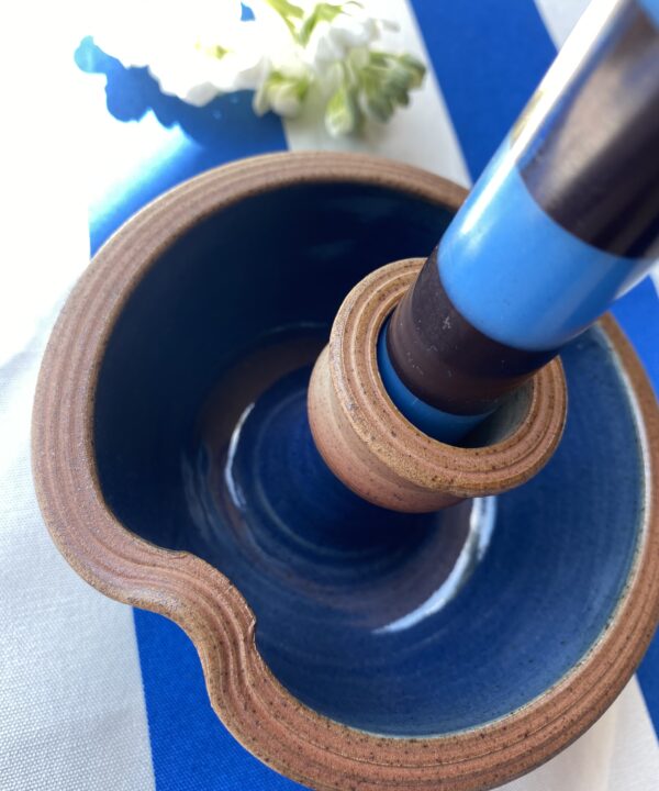 Close up shot of a blue pottery candlestick.