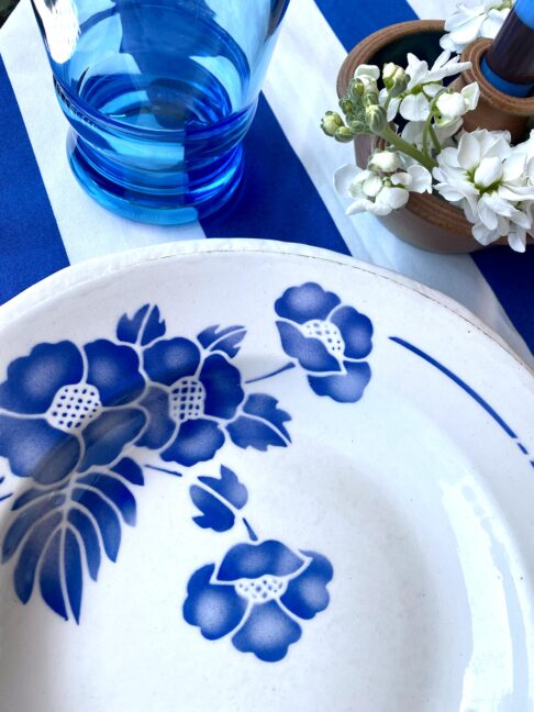 A blue and white place setting with vintage French floral bowl.