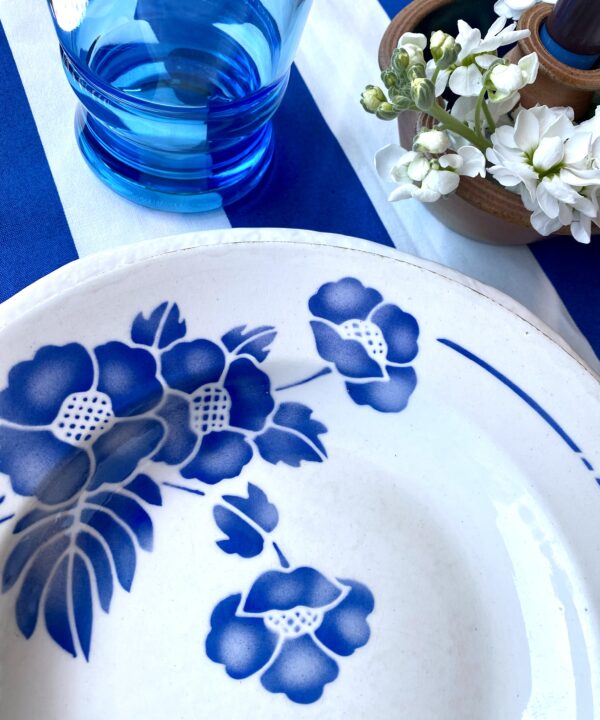 A blue and white place setting with vintage French floral bowl.