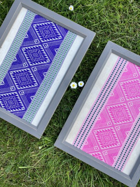 Gallery wall art additions by way of colourful, pink and purple framed textile art from Thailand, snapped here against a grass green backdrop!