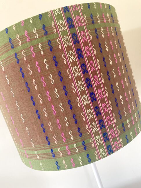 A chic green, pink and blue patterned lampshade with delicate stitched detailing.