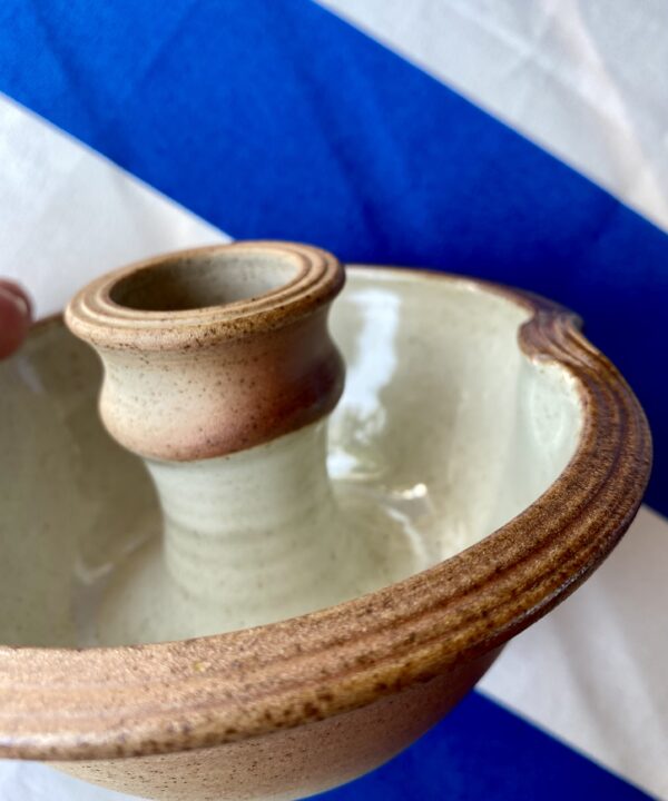 Detail of an ivory-glazed, pottery, ceramic candlestick.