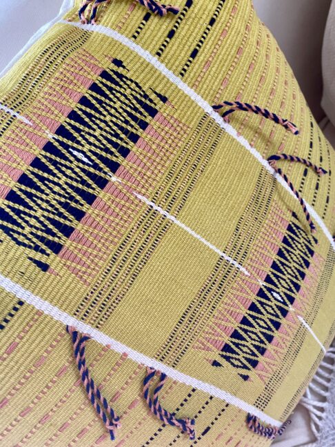 Acid yellow cushions with tassels handwoven in India.