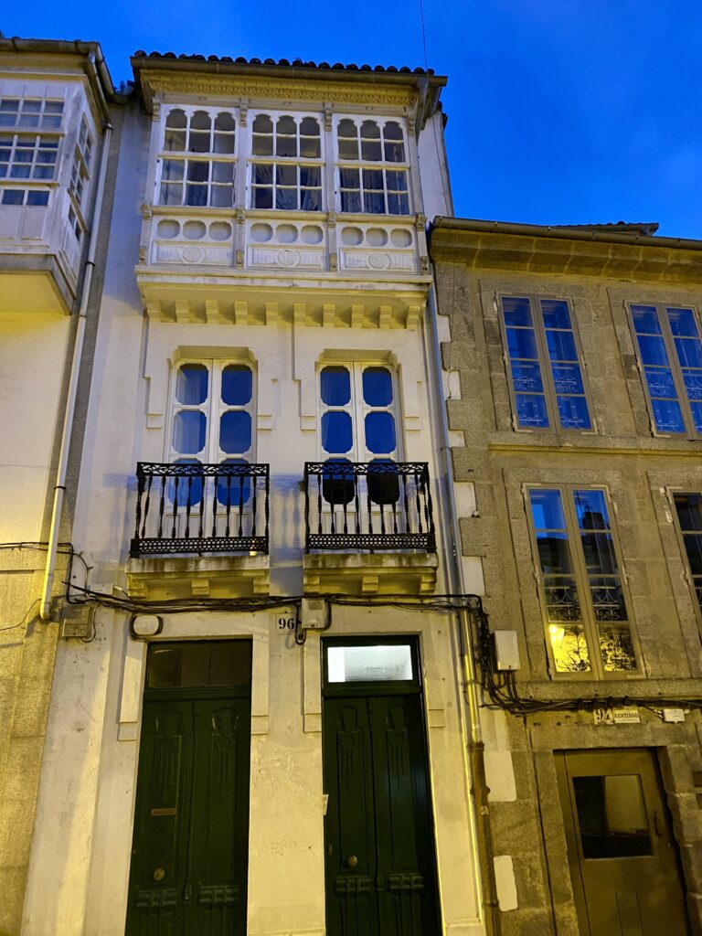 Juliet balconies on elegant, night time architecture in Santiago De Compostela, Spain.