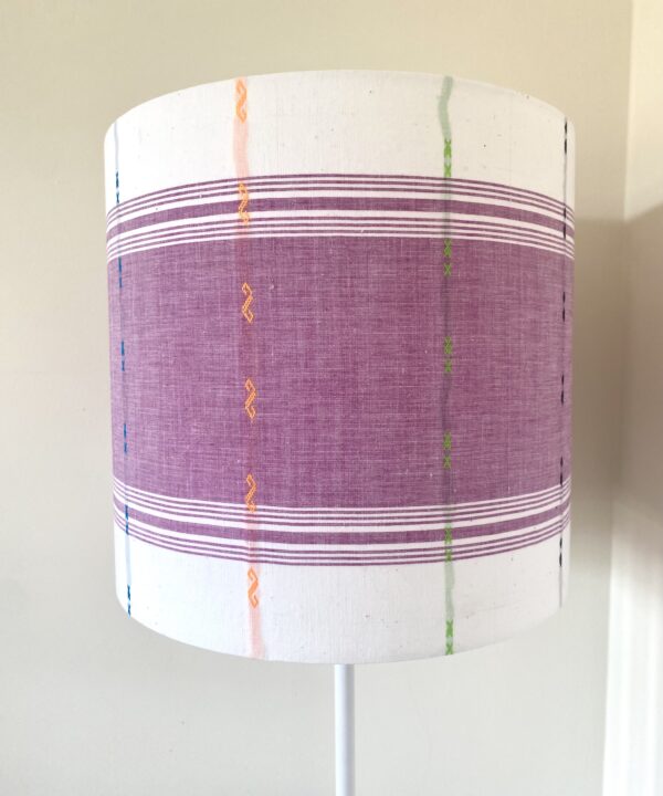 Mauve lampshades with white background and multi-coloured detailing.