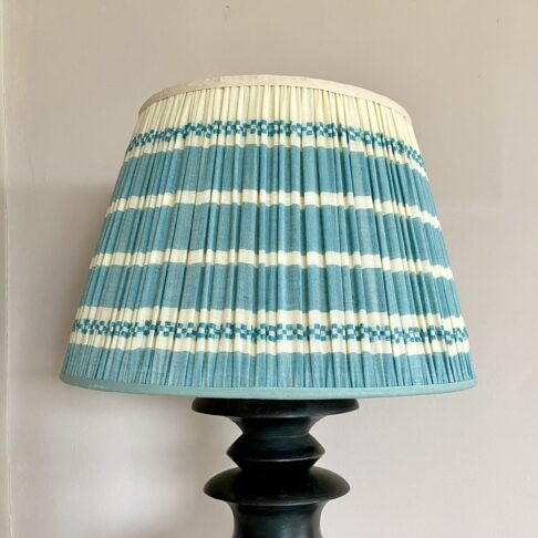 Pale blue gathered lampshades in hand-loomed cotton with a horizontal striped design.