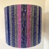 Pink and navy lampshades in a vertical stripe design made from hand-loomed Thai textiles.