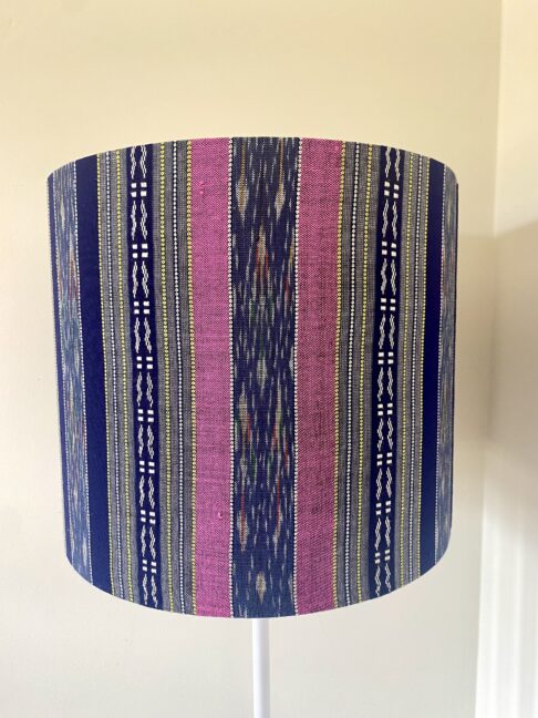 Pink and navy lampshades in a vertical stripe design made from hand-loomed Thai textiles.