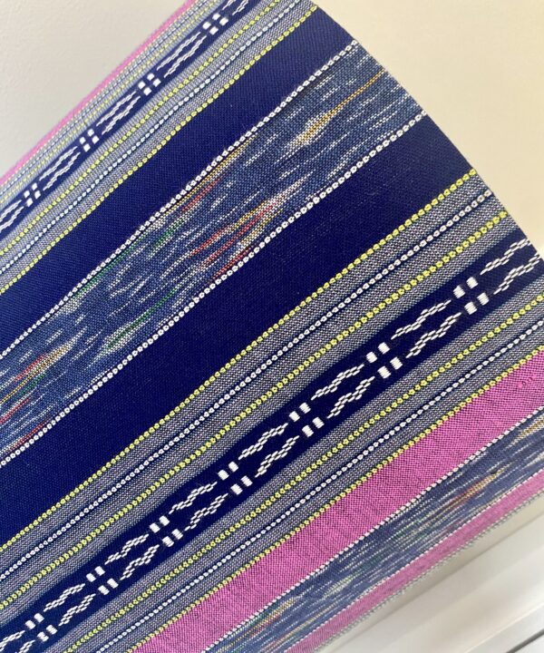 A pink and navy striped lampshade in a hand-loomed Thai textile.