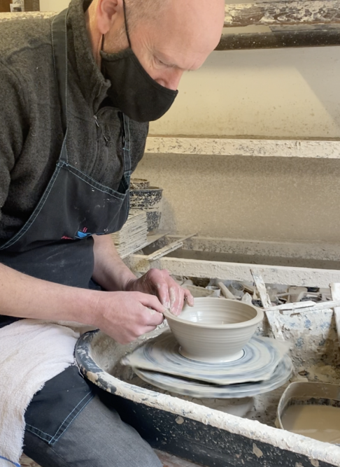 Making a pot on the wheel in a Scottish pottery studio.