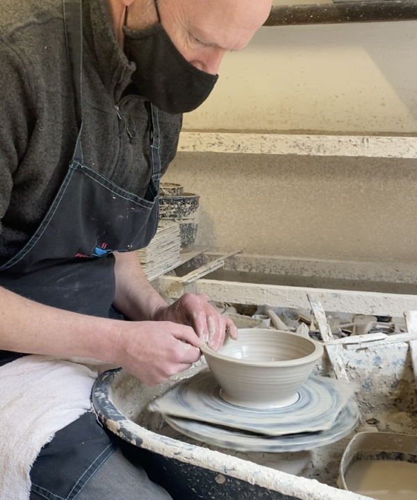 Making a pot on the wheel in a Scottish pottery studio.