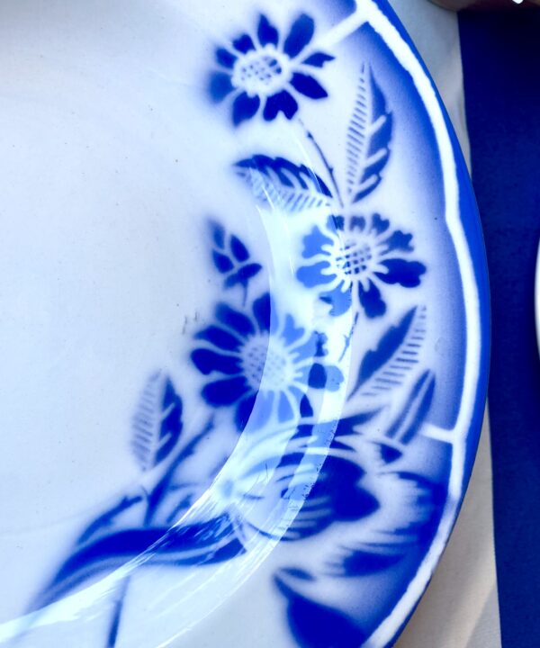 Close up detail of French transferware floral on a ceramic dish in blue and white.