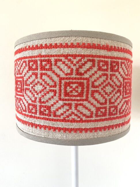 A petite, hand-embroidered vintage lampshade in red on neutral.