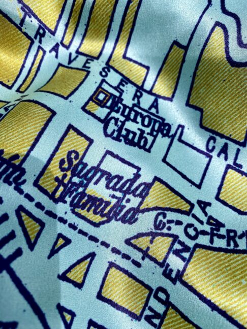 Detail of the Sagrada Familia church on a luxury silk scarf with a vintage map print of Barcelona.