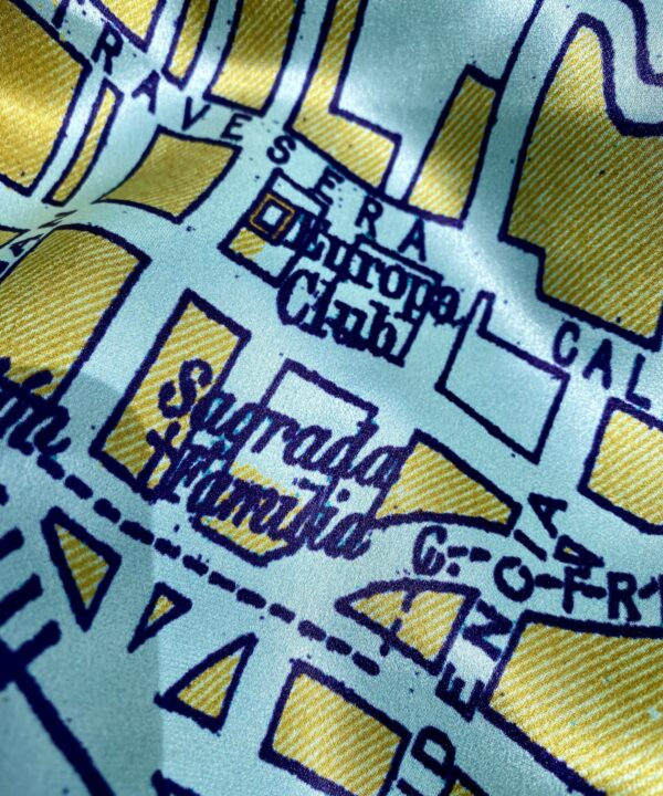 Detail of the Sagrada Familia church on a luxury silk scarf with a vintage map print of Barcelona.