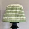 Green gathered lampshade in handwoven cotton with a subtle stripe design.