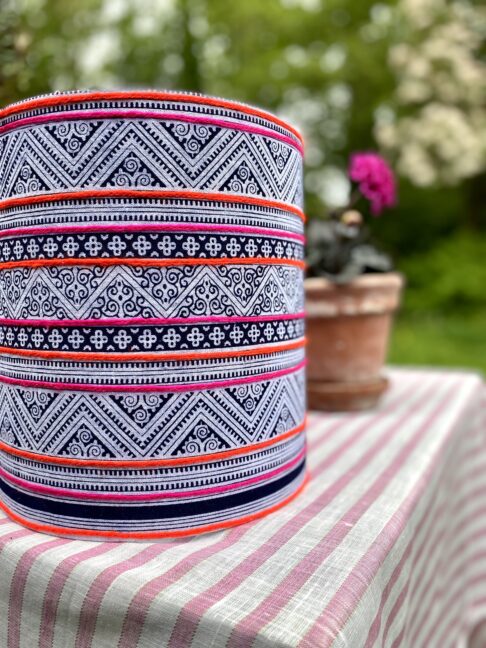 A drum lampshade handmade using a vintage Thai indigo print with pink and orange stripes.