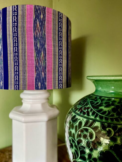 An elegant pink and navy drum shade on a white china base.