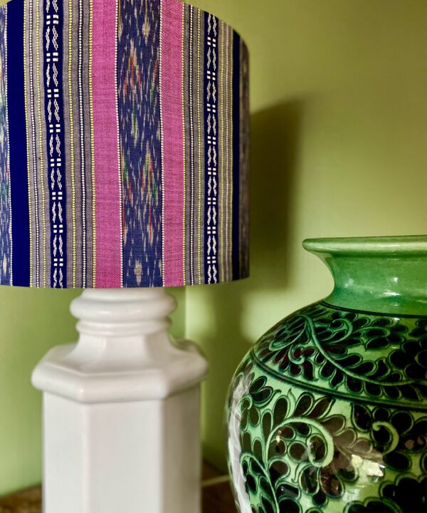 An elegant pink and navy drum shade on a white china base.