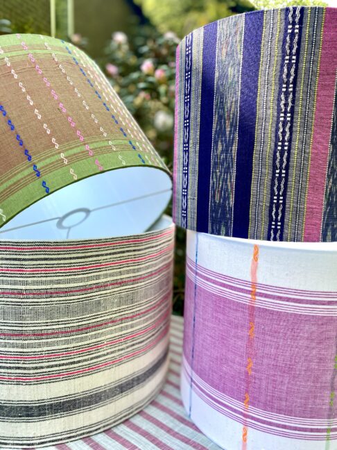 Eclectic lamps and shades: a selection of striped drum lampshades, handmade from Thai textiles.