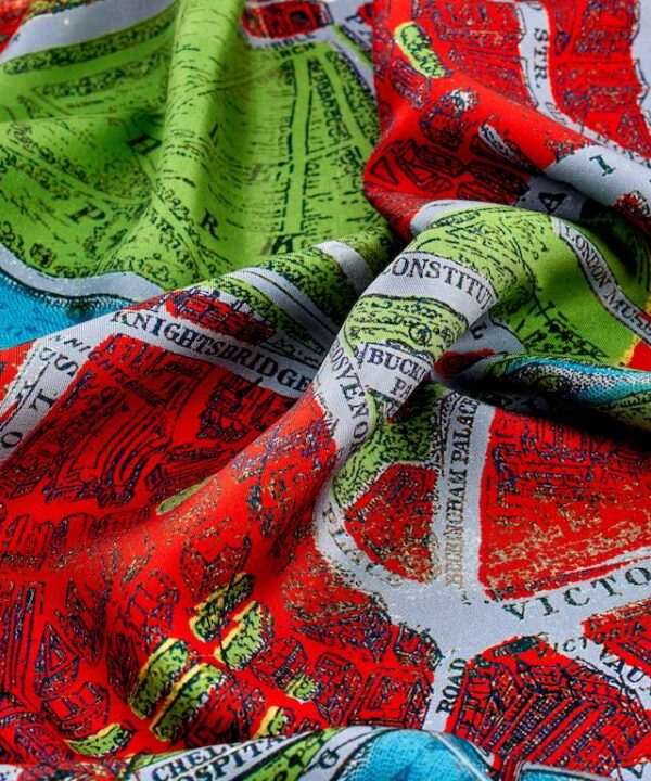 Close up image of a luxury silk scarf with a vintage London map print in red.