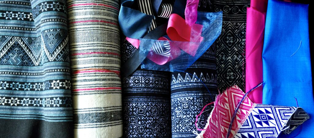 A collection of printed indigo and woven hemp Thai textiles with pink and blue Thai silks.