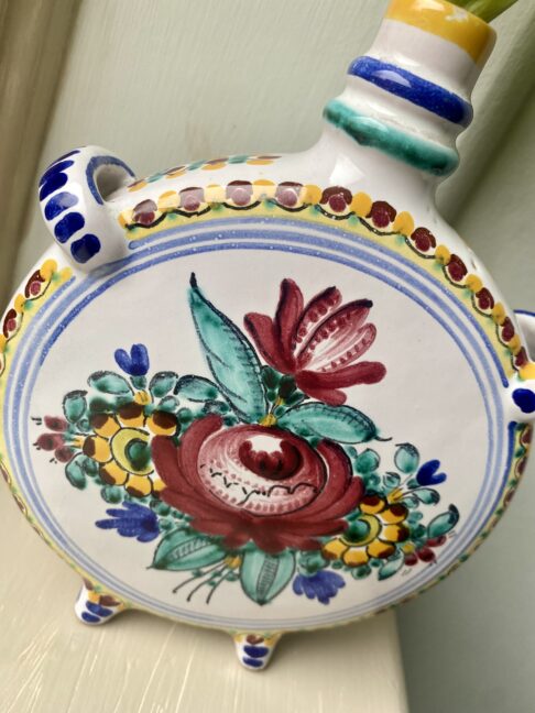 A hand-painted rose on the side of a handmade, Portuguese bud vase.