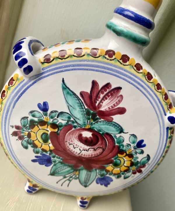 A hand-painted rose on the side of a handmade, Portuguese bud vase.