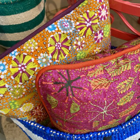 Multi-coloured mini cushions in bold, bright Aboriginal art prints on linen.