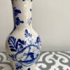 Blue and white Delft ceramic vase depicting flowers and windmills.