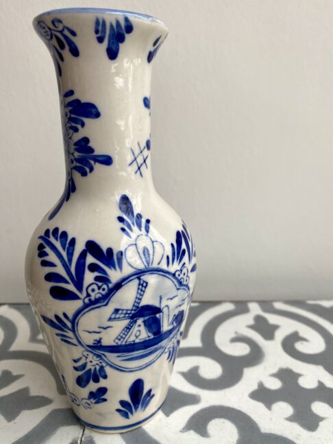 Blue and white Delft ceramic vase depicting flowers and windmills.