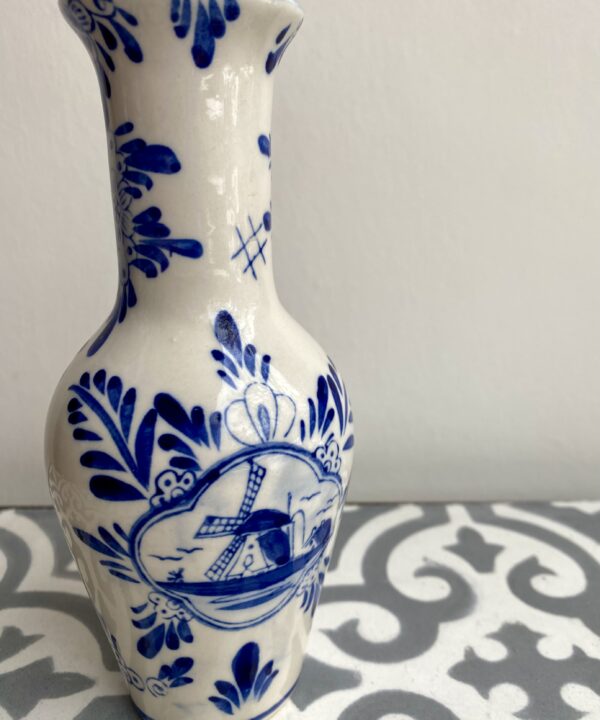 Blue and white Delft ceramic vase depicting flowers and windmills.