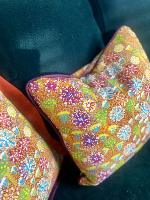 Colourful lumbar cushion with an indigenous Aboriginal art print on linen. with burgundy piping.