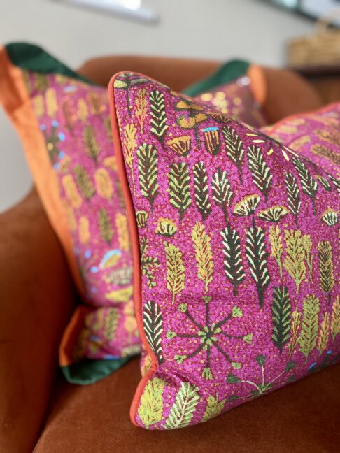 Pink lumbar cushion with a floral, indigenous Aboriginal art design on linen.