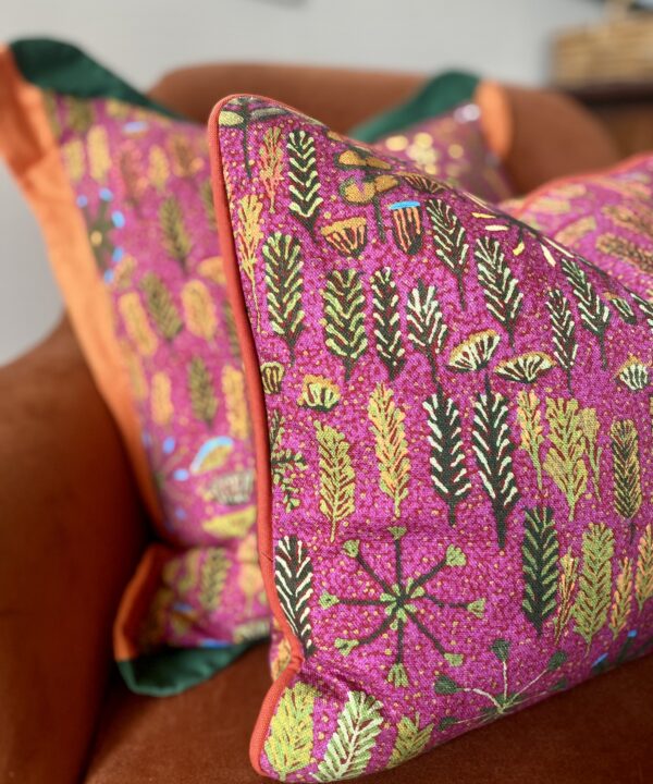 Pink lumbar cushion with a floral, indigenous Aboriginal art design on linen.