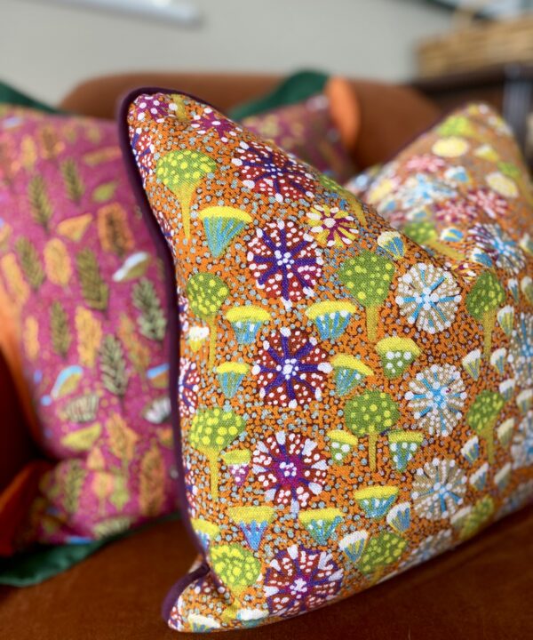 Orange lumbar cushion with floral, indigenous Aboriginal art on linen design.
